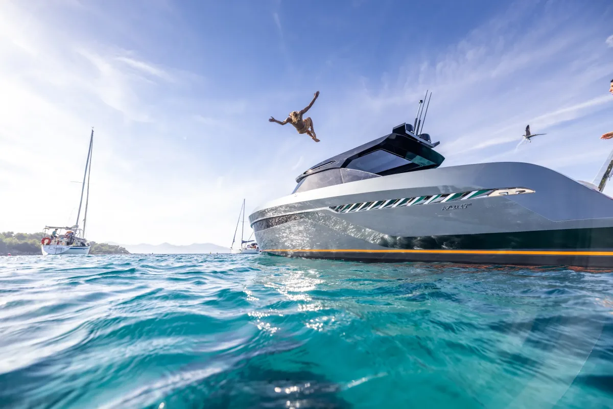 Guest diving from the bow of a Bekkers AZUR 45HT into turquoise water