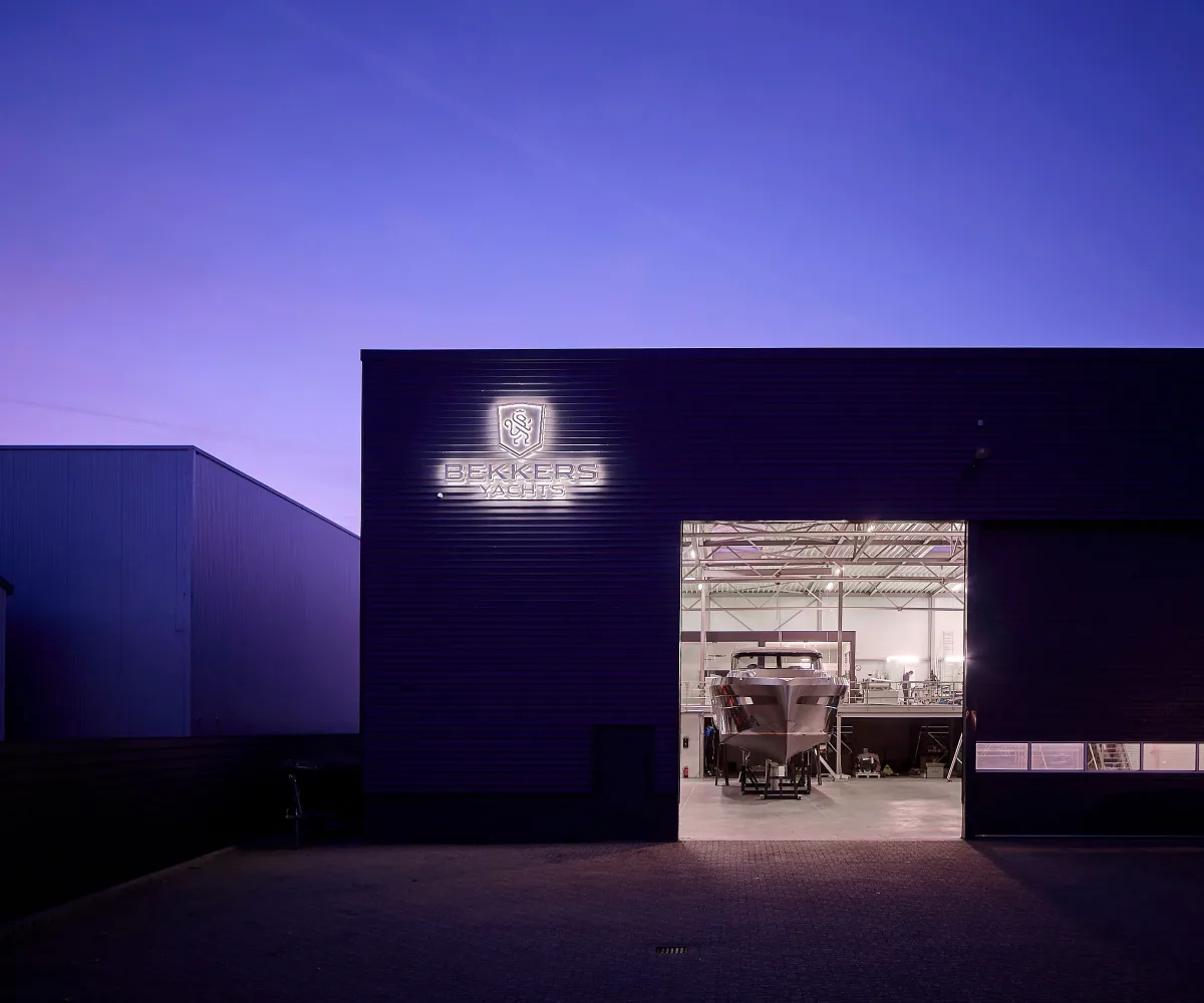 The Bekkers Yachts yard in Heusden at dusk, with a yacht in build inside the hall